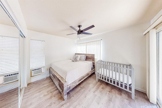 bedroom featuring cooling unit, a ceiling fan, and wood finished floors