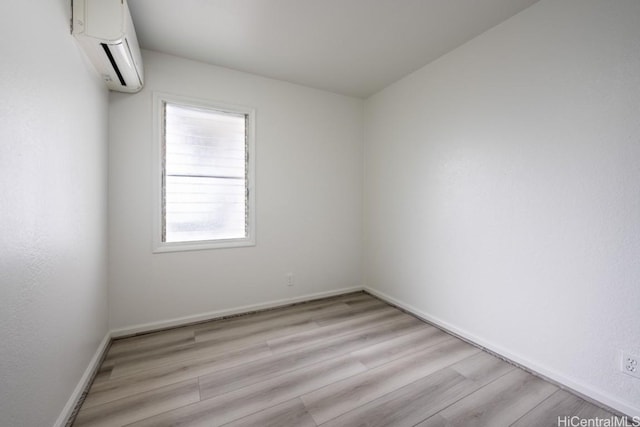 spare room with light hardwood / wood-style flooring and a wall mounted AC