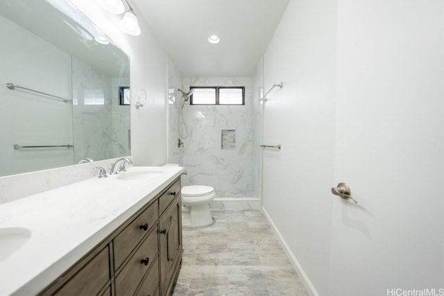 bathroom featuring vanity, toilet, and tiled shower