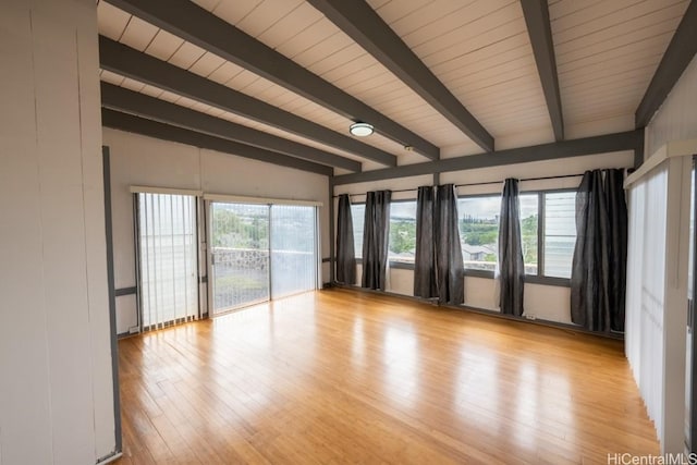 empty room featuring beam ceiling and light hardwood / wood-style floors