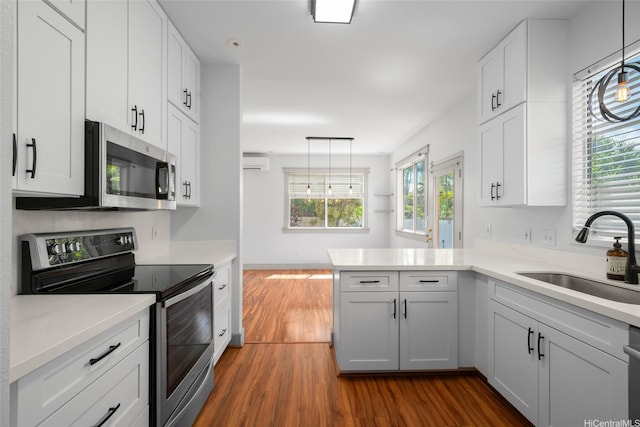 94-1092 Kikepa St Unit 179, Waipahu, HI 96797 - kitchen featuring appliances with stainless steel finishes, a wall unit AC, dark wood-style floors, and healthy amount of natural light