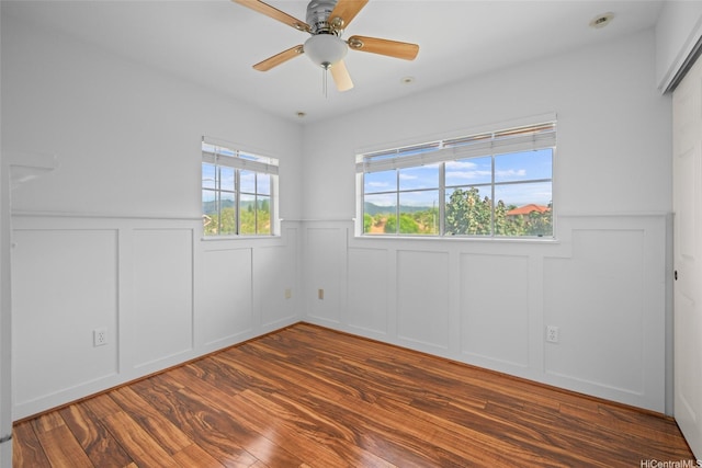 94-1092 Kikepa St Unit 179, Waipahu, HI 96797 - unfurnished room with a decorative wall, a wainscoted wall, wood finished floors, and ceiling fan