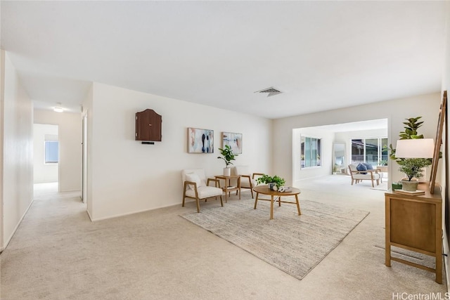 living area with light carpet and visible vents