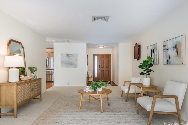 sitting room with visible vents and light colored carpet