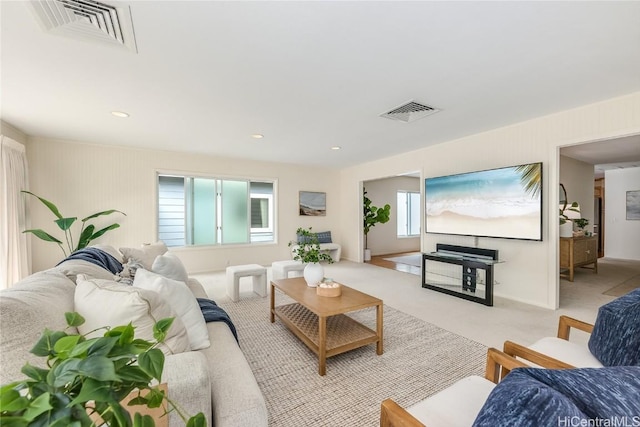 living room featuring carpet floors, baseboards, visible vents, and recessed lighting