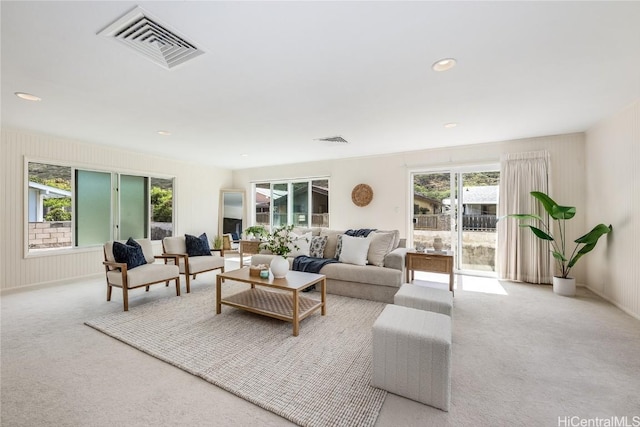 living area featuring carpet floors, recessed lighting, and visible vents