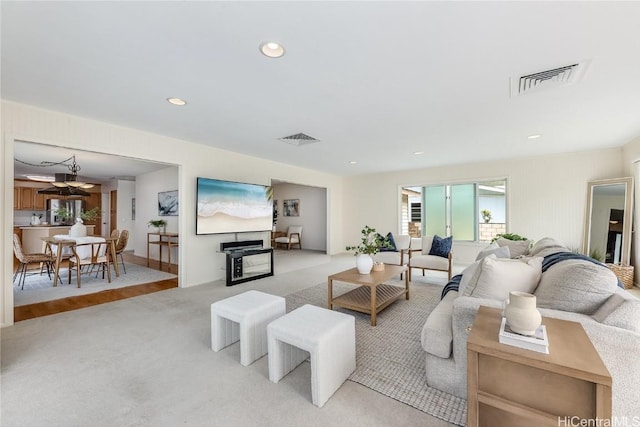 living area featuring light carpet, visible vents, and recessed lighting