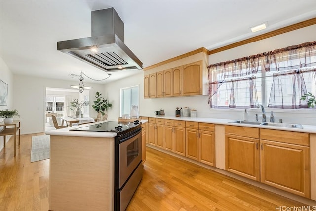 kitchen with a sink, a healthy amount of sunlight, island exhaust hood, and electric stove