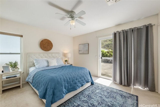 bedroom with access to outside, a ceiling fan, and light colored carpet