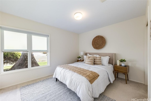 bedroom with baseboards and light colored carpet