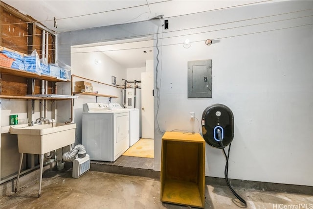 laundry room with laundry area, electric panel, washer and dryer, water heater, and a sink