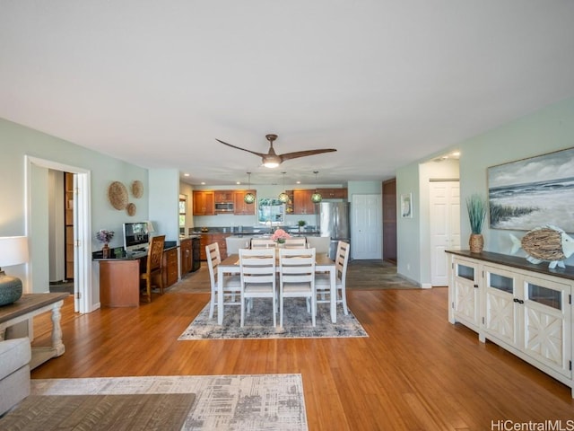 dining space with light hardwood / wood-style flooring and ceiling fan