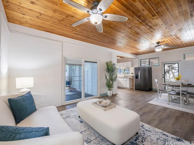 living room featuring wood-type flooring, sink, and wooden ceiling