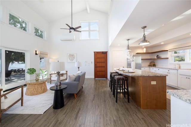 living room featuring beam ceiling, dark wood-type flooring, high vaulted ceiling, and ceiling fan