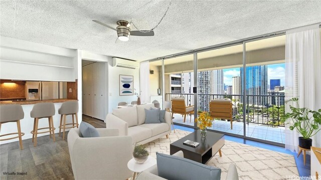 living room featuring ceiling fan, expansive windows, a wall mounted AC, and hardwood / wood-style flooring