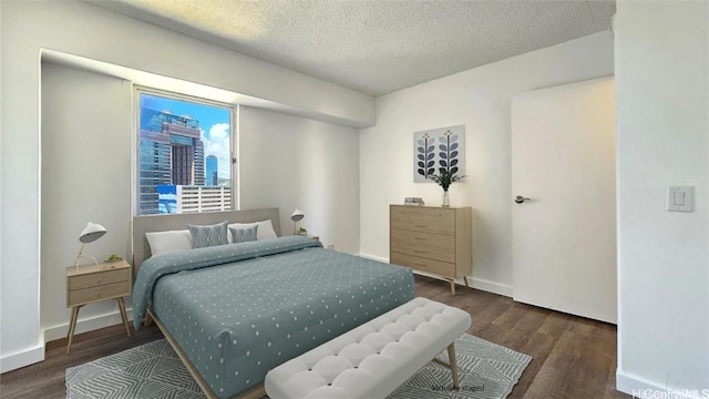 bedroom with dark wood-type flooring and a textured ceiling