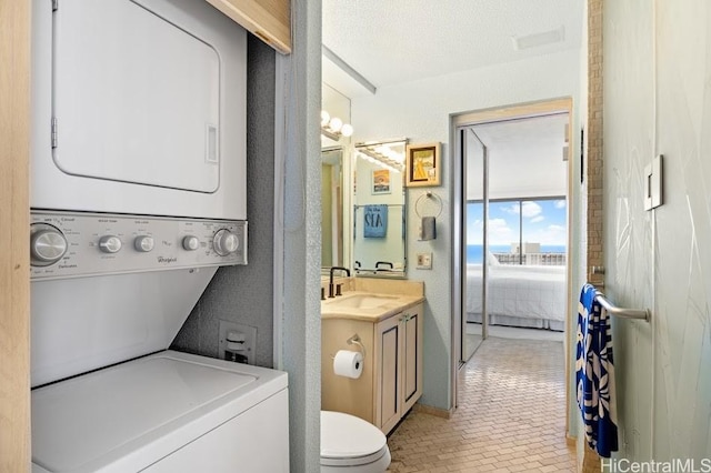 laundry area featuring sink and stacked washer and dryer