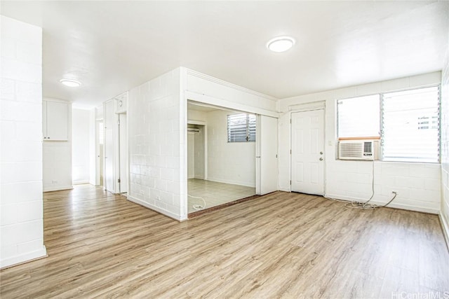 unfurnished room featuring cooling unit and light hardwood / wood-style floors