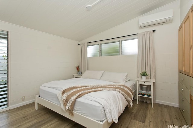 bedroom with vaulted ceiling, an AC wall unit, hardwood / wood-style floors, and multiple windows