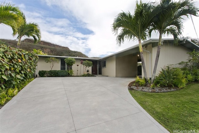 view of front facade with a carport and a front lawn