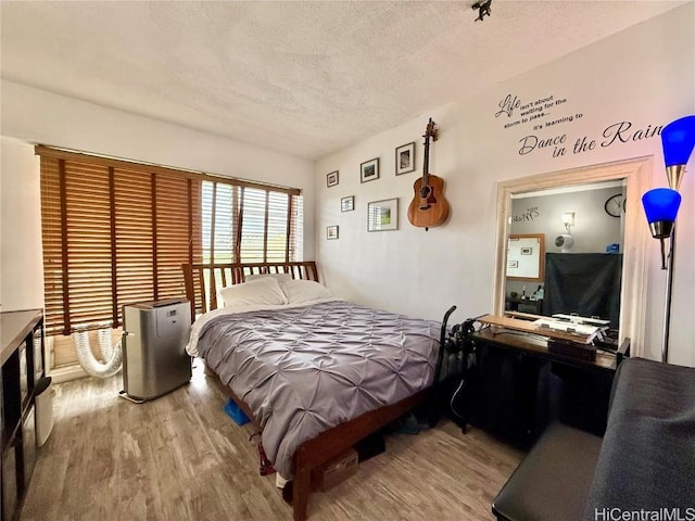 bedroom featuring a textured ceiling and light hardwood / wood-style floors