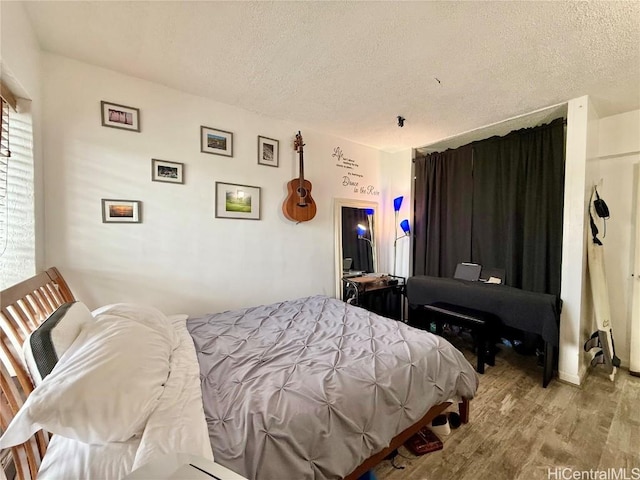 bedroom with a textured ceiling and light hardwood / wood-style flooring