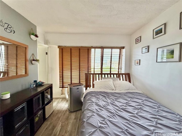 bedroom featuring a textured ceiling and hardwood / wood-style flooring