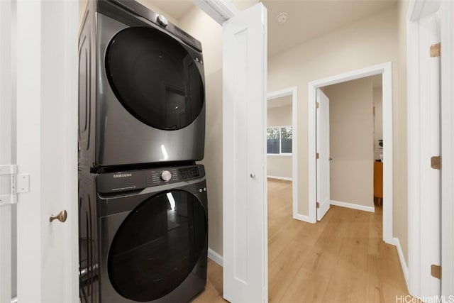 laundry area featuring light wood-type flooring and stacked washer / drying machine