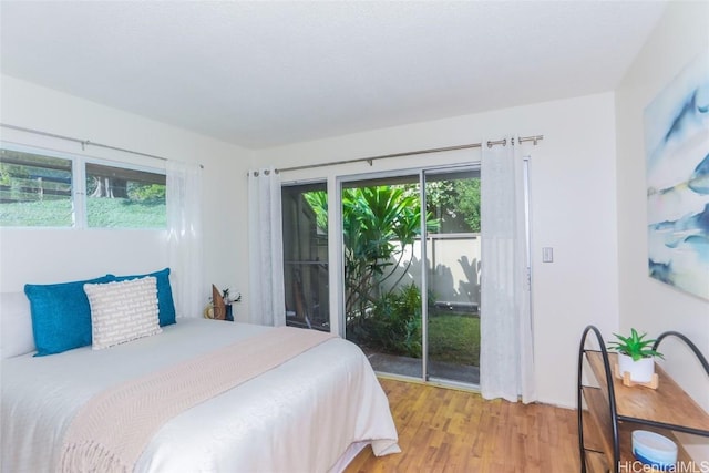 bedroom featuring access to exterior and light wood-type flooring