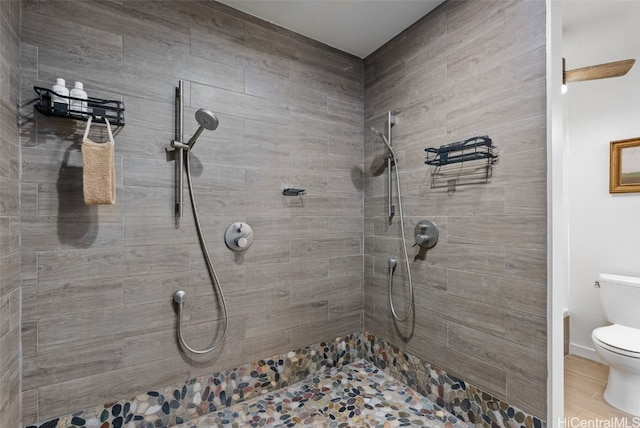 bathroom featuring toilet and tiled shower