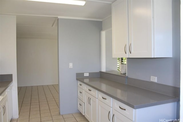 kitchen featuring white cabinetry, light tile patterned floors, and crown molding