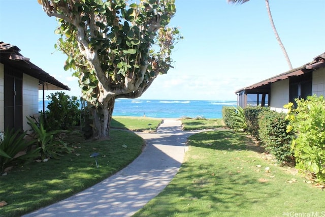 view of community with a lawn and a water view