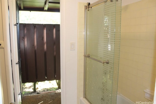 bathroom featuring combined bath / shower with glass door