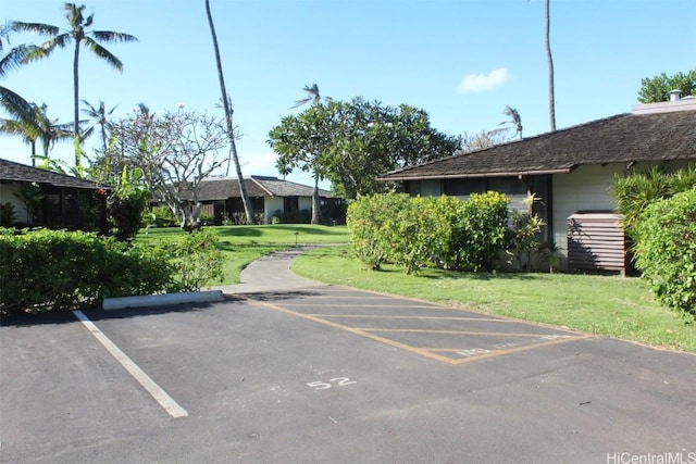 view of parking / parking lot featuring a yard