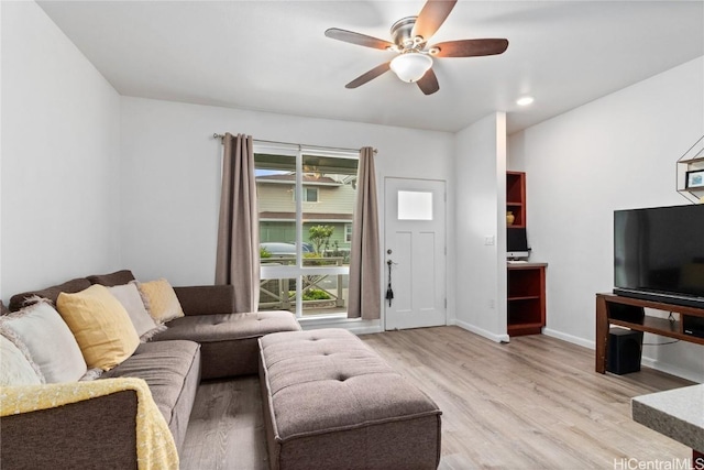 living room featuring ceiling fan and light hardwood / wood-style flooring