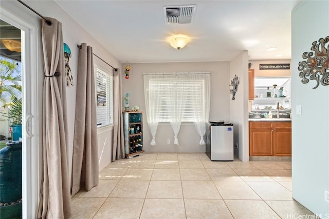 corridor with sink and light tile patterned floors