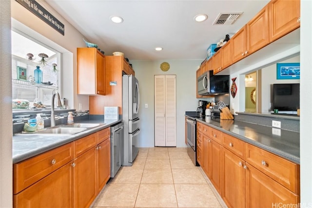 kitchen featuring appliances with stainless steel finishes, sink, and light tile patterned floors