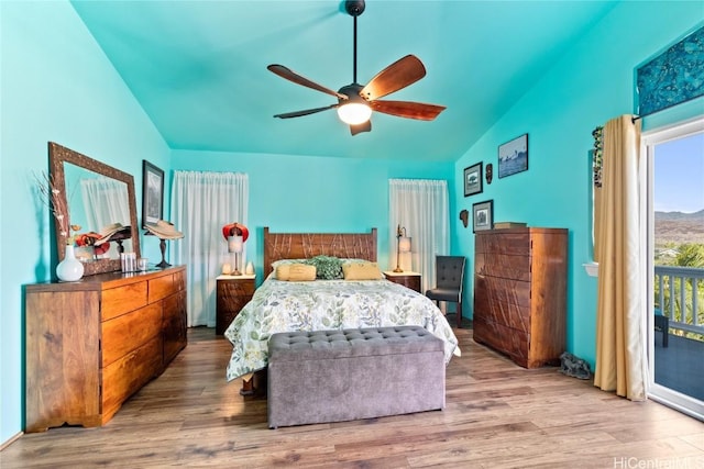 bedroom featuring lofted ceiling, access to exterior, hardwood / wood-style flooring, and ceiling fan