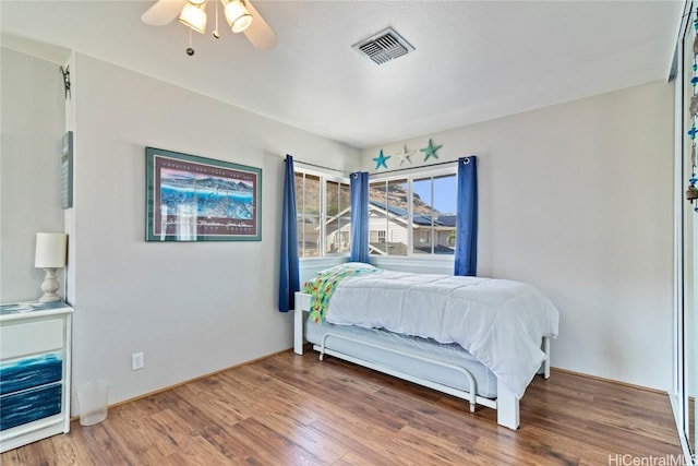 bedroom with hardwood / wood-style floors and ceiling fan