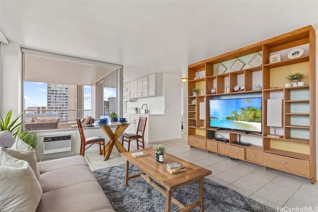 tiled living room featuring an AC wall unit and sink