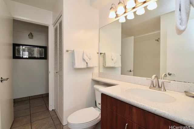 bathroom with toilet, tile patterned flooring, and vanity