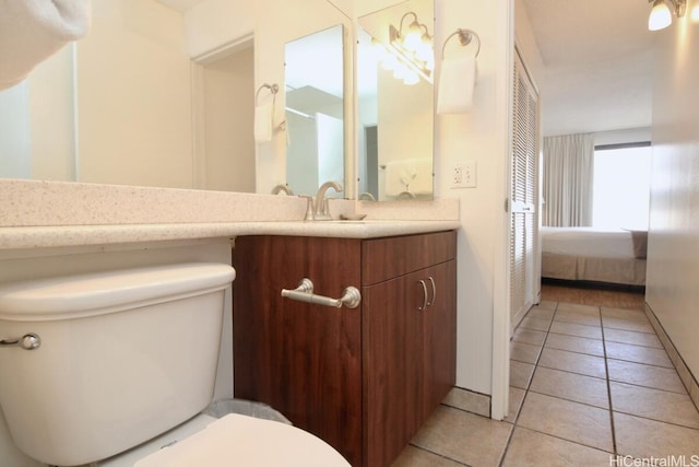 bathroom featuring toilet, vanity, and tile patterned flooring