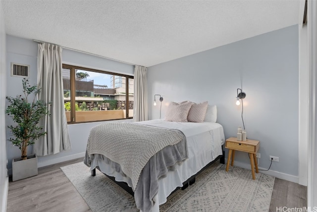 bedroom featuring a textured ceiling and light wood-type flooring