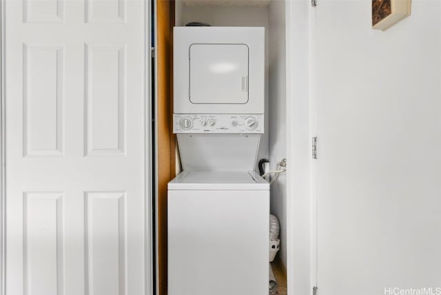 clothes washing area featuring stacked washer and dryer