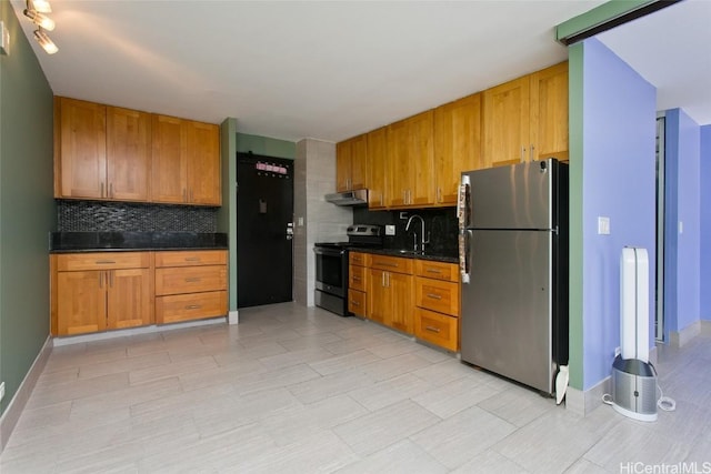 kitchen featuring appliances with stainless steel finishes, decorative backsplash, dark stone countertops, and sink