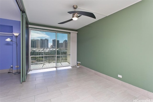 spare room with ceiling fan, plenty of natural light, and floor to ceiling windows