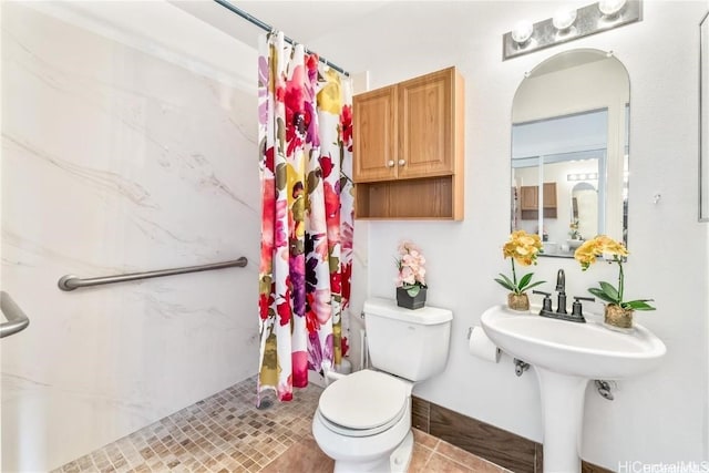 bathroom featuring curtained shower, toilet, and tile patterned flooring