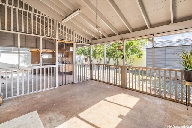 unfurnished sunroom featuring vaulted ceiling