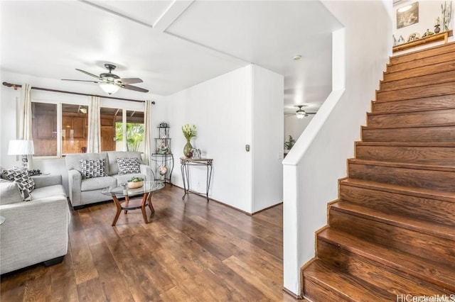 living room featuring ceiling fan and dark wood-type flooring