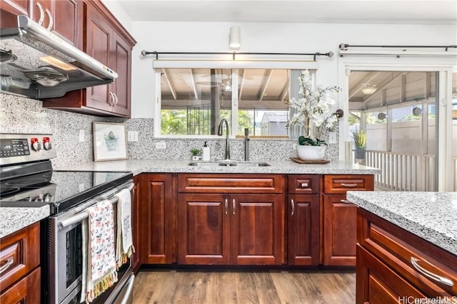 kitchen with light stone countertops, sink, decorative backsplash, and stainless steel electric range oven